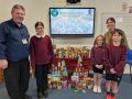 Pupils from Burston Primary School, alongside Pastor Sam and Helen Youngman from Citizens Advice stand next to a donation of food items.