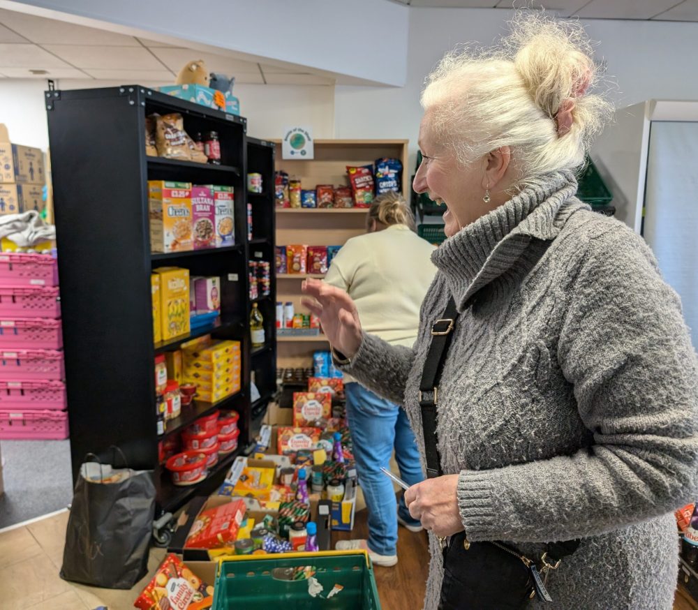 A lady looking at food at a food hub and smiling